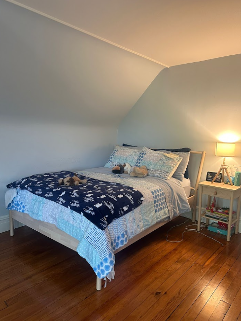 AFTER: Same bedroom with neatly made bed, arranged plush toy dog, and clean hardwood floor